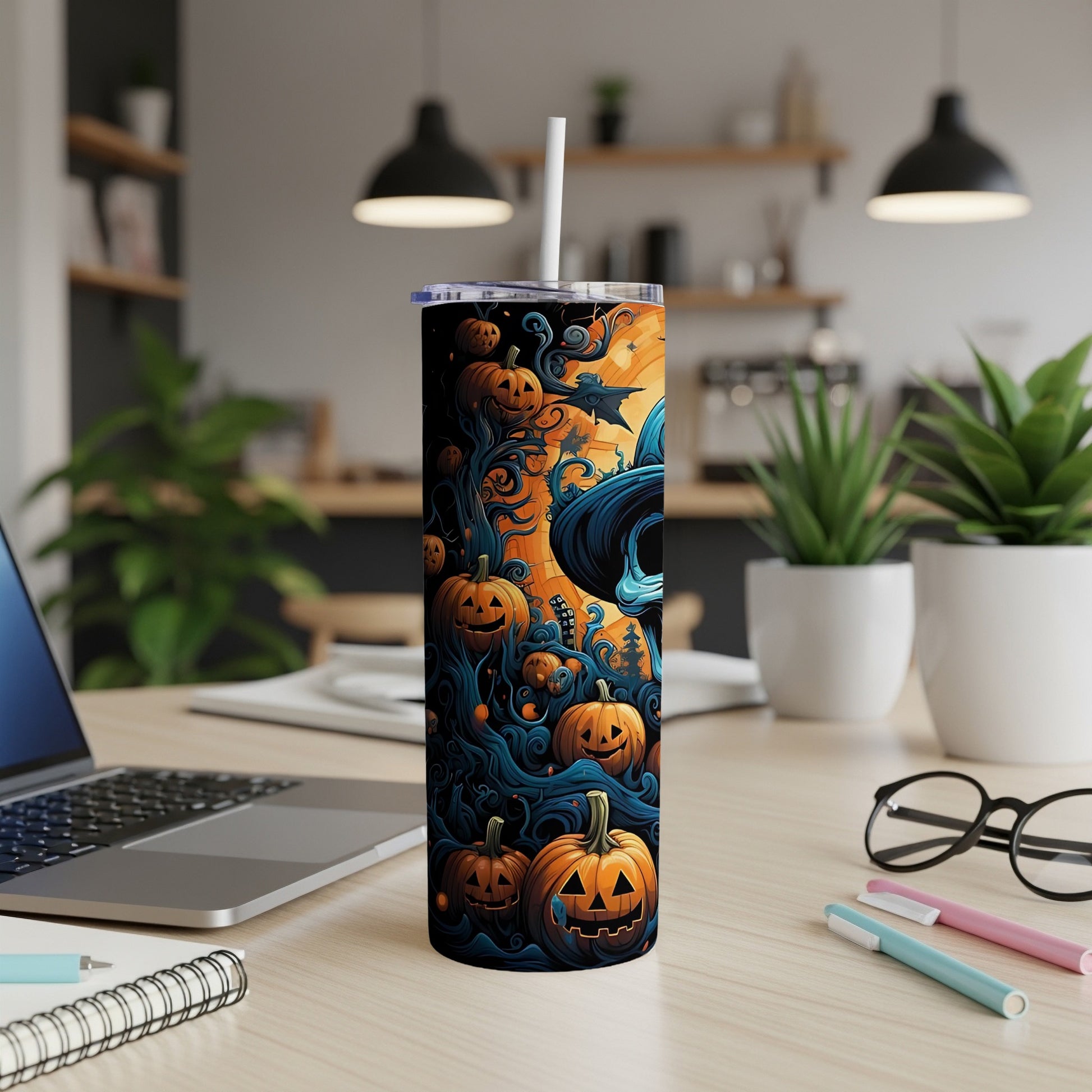 Tumbler with jack-o'-lanterns and witch hat design on a desk.