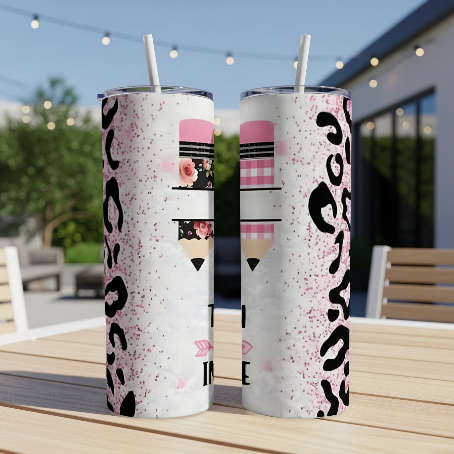 Two tumblers with pink pencil and leopard print design, sitting on a table.
