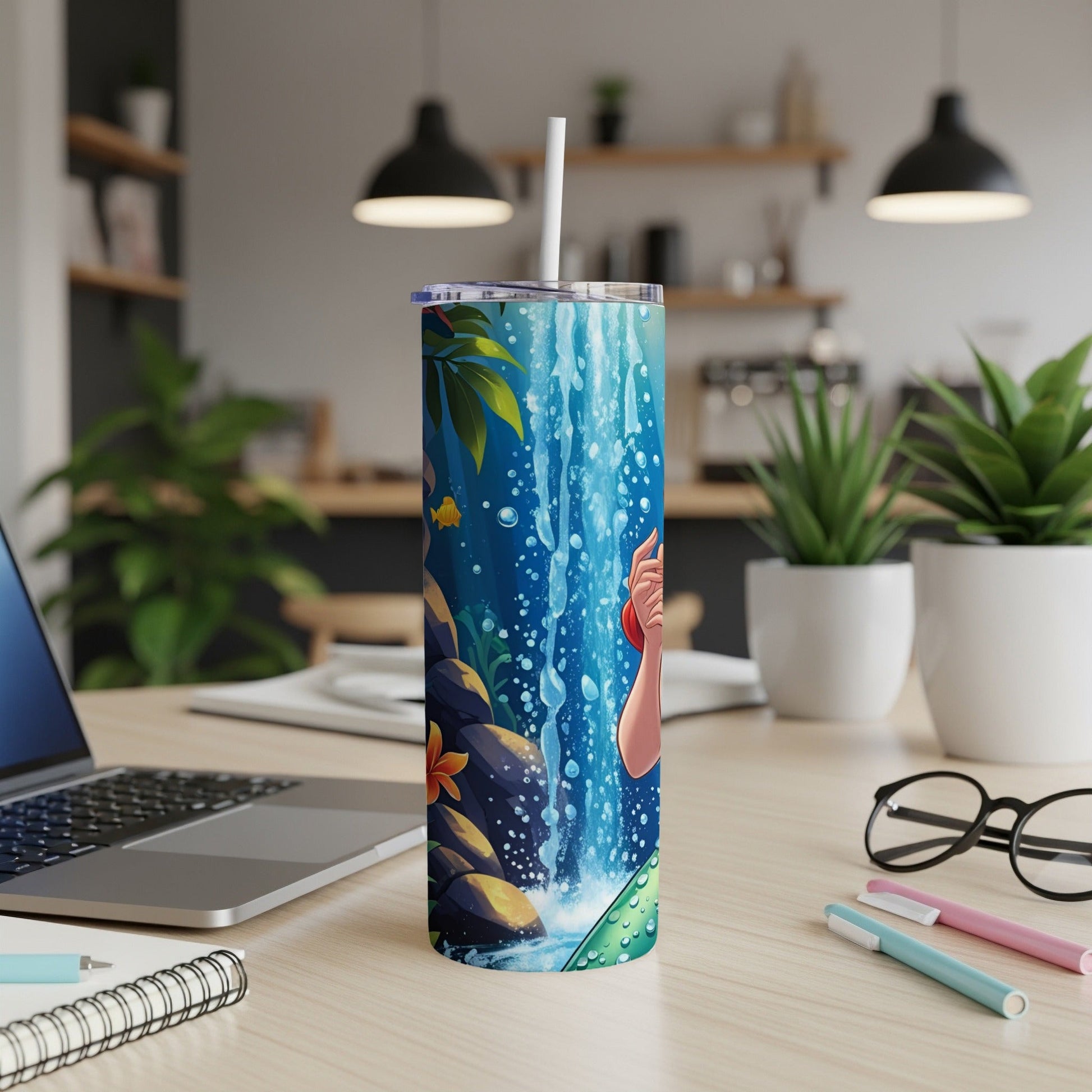 Tumbler with waterfall, fish, and a hand holding a straw.