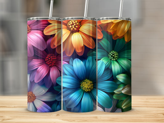 Three colorful floral tumblers with straws on a wooden surface.