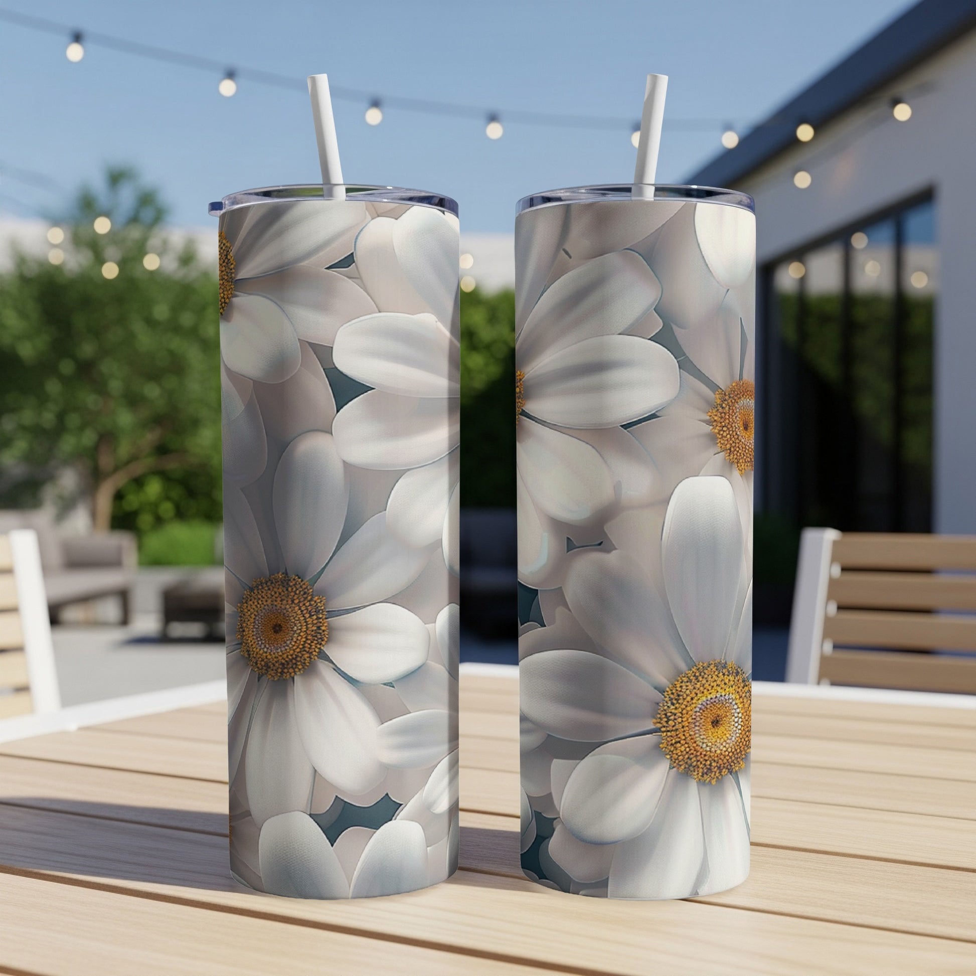 Two tall tumblers with white daisy floral pattern on a wooden table.