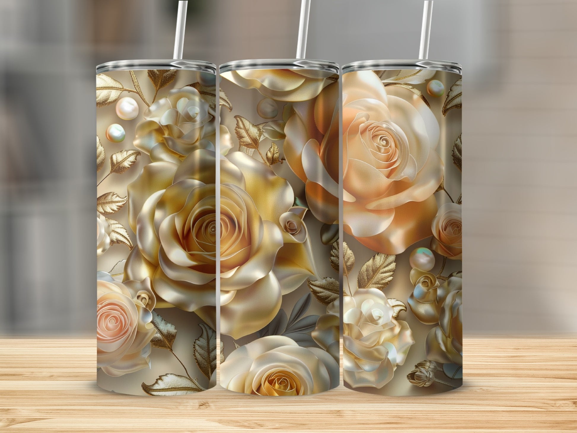 Three golden rose tumblers with pearl accents on a wooden surface.