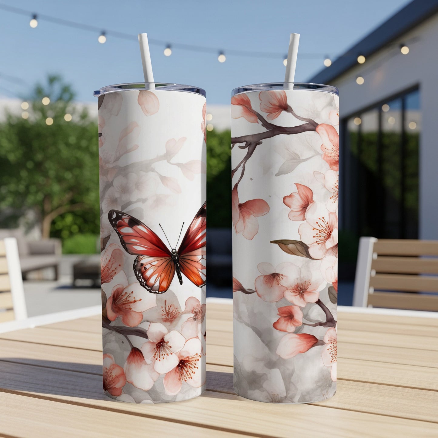 Two white tumblers with a butterfly and cherry blossoms design.