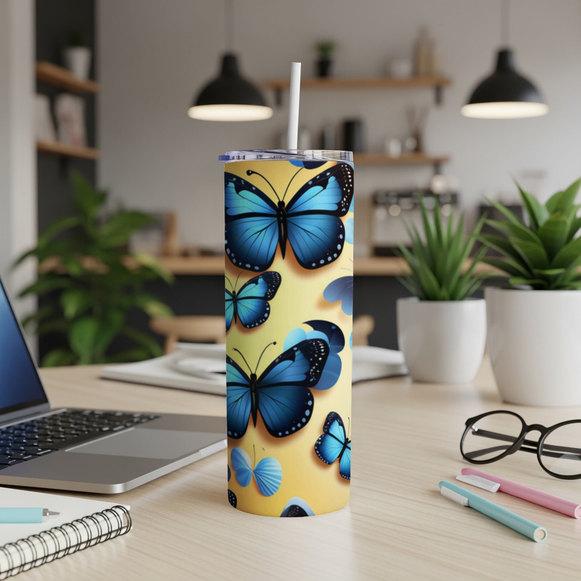 Blue butterflies on a yellow tumbler with a straw.