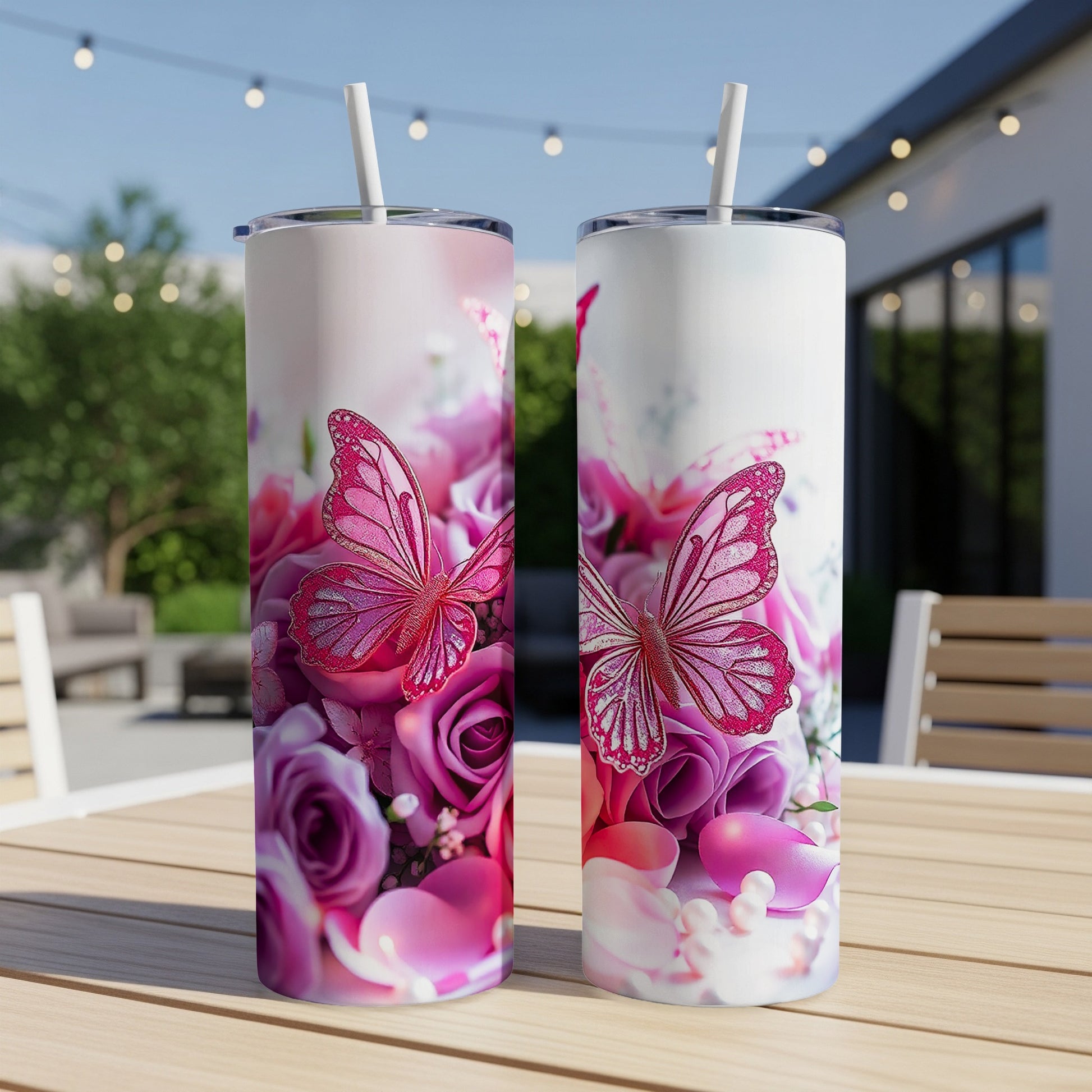 Two tumblers with pink butterflies and roses, resting on a wooden table.