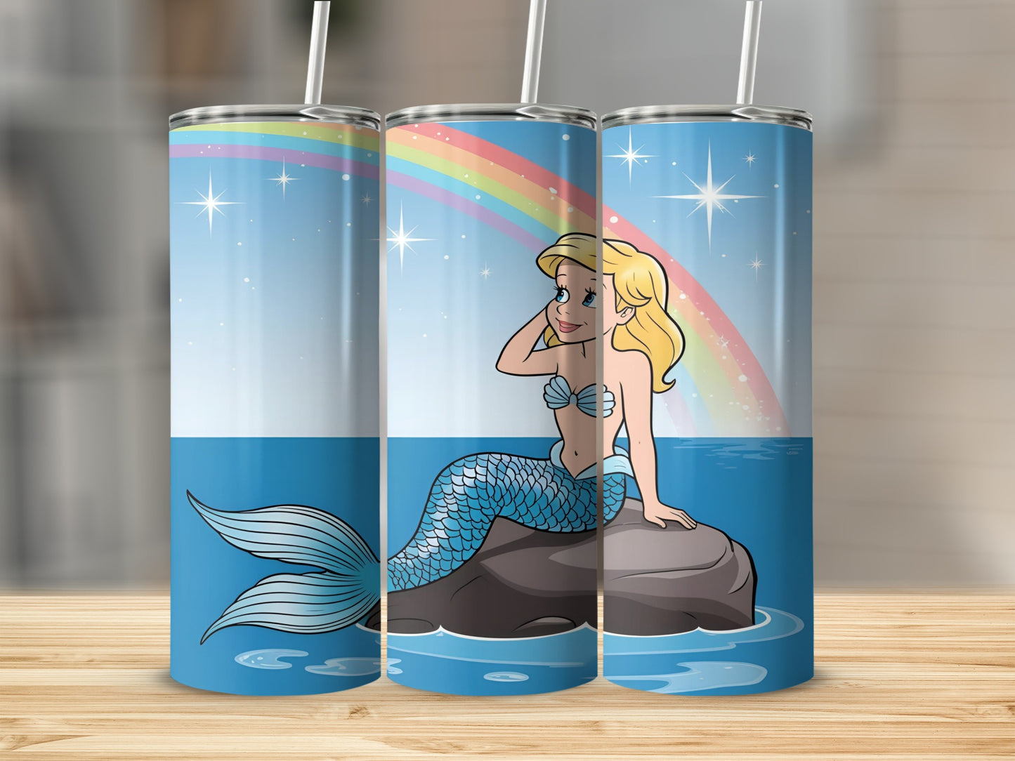 Cartoon mermaid with blue tail sits on rock under rainbow.
