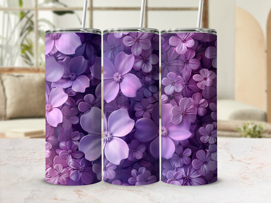 Three purple floral tumblers with straws on a marble surface.