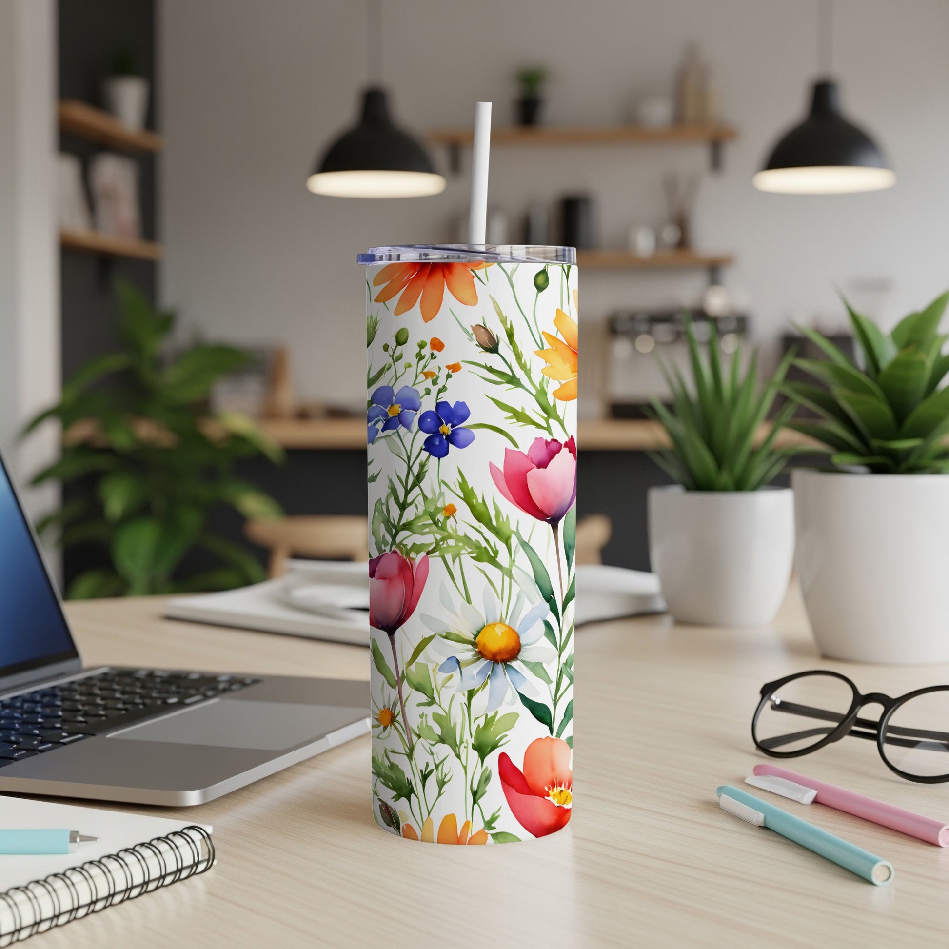 White tumbler with colorful floral pattern on a desk.