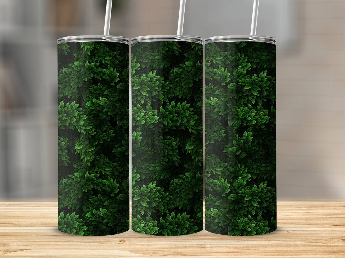 Three tumblers with a dark green leafy pattern sit on a wooden surface.