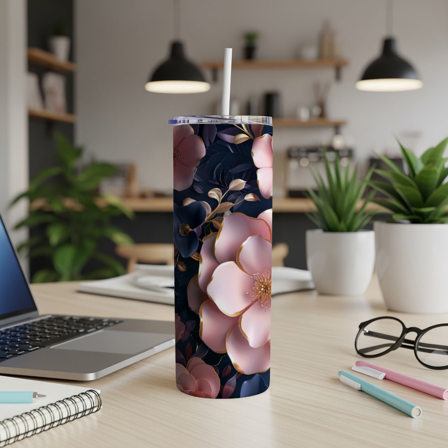 Tumbler with dark floral pattern and pink accents, sitting on a desk.