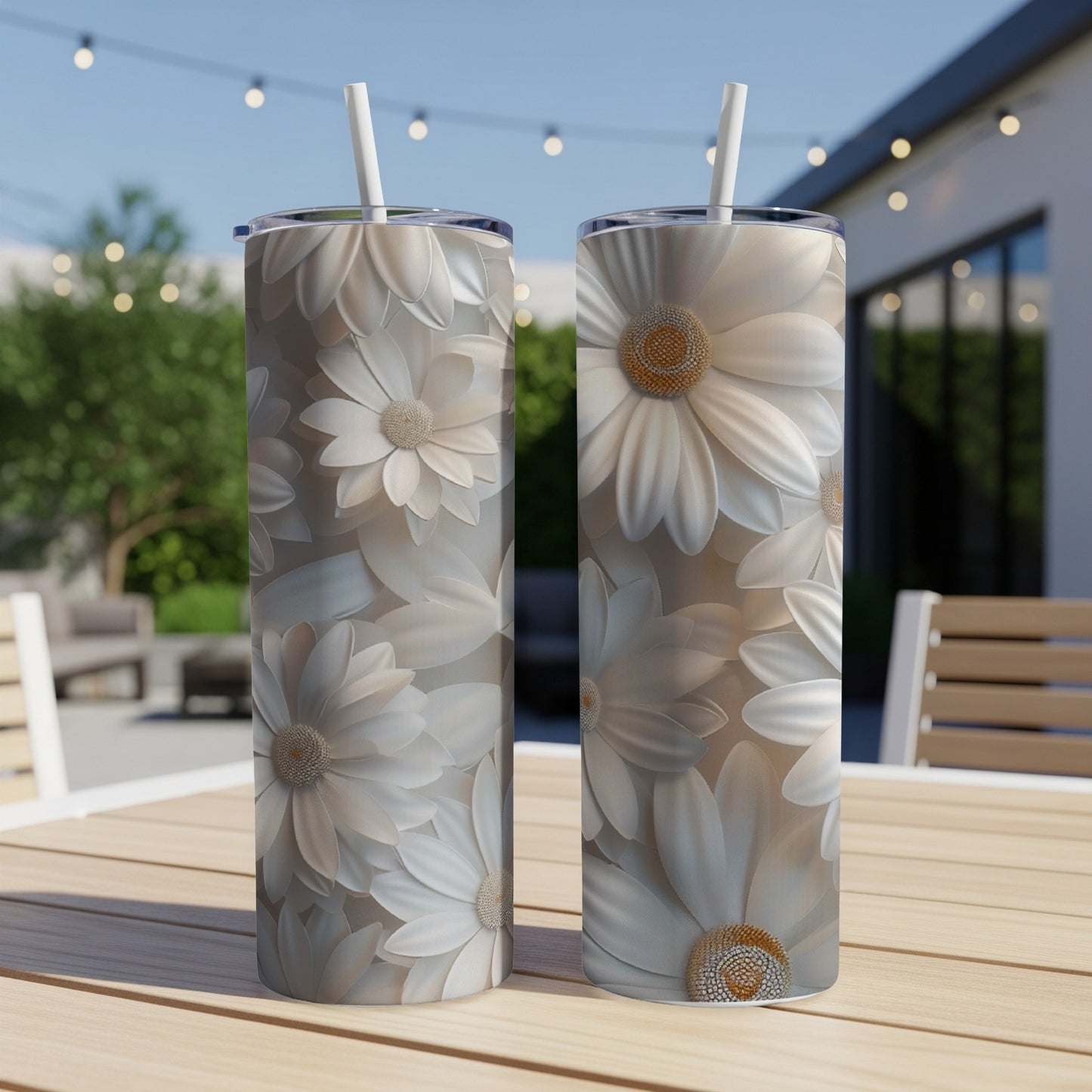 Two white daisy tumblers with straws sit on a table outdoors.
