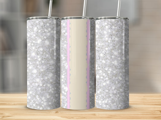 Three glittery tumblers with pastel accents on a wooden surface.