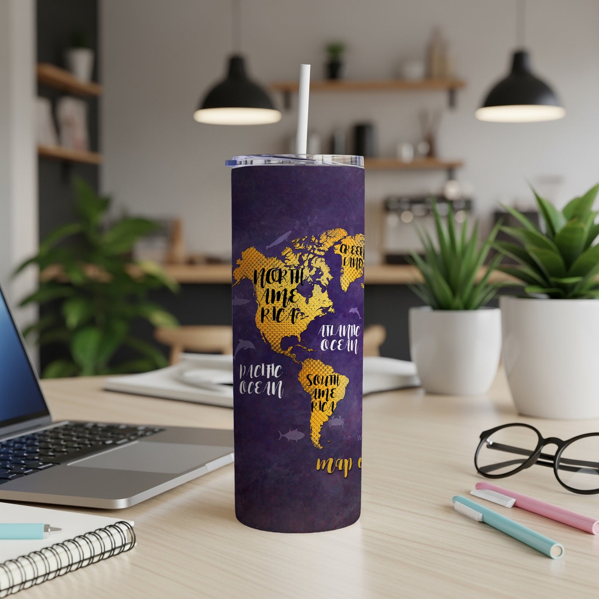Purple tumbler with gold world map design, showing North and South America.