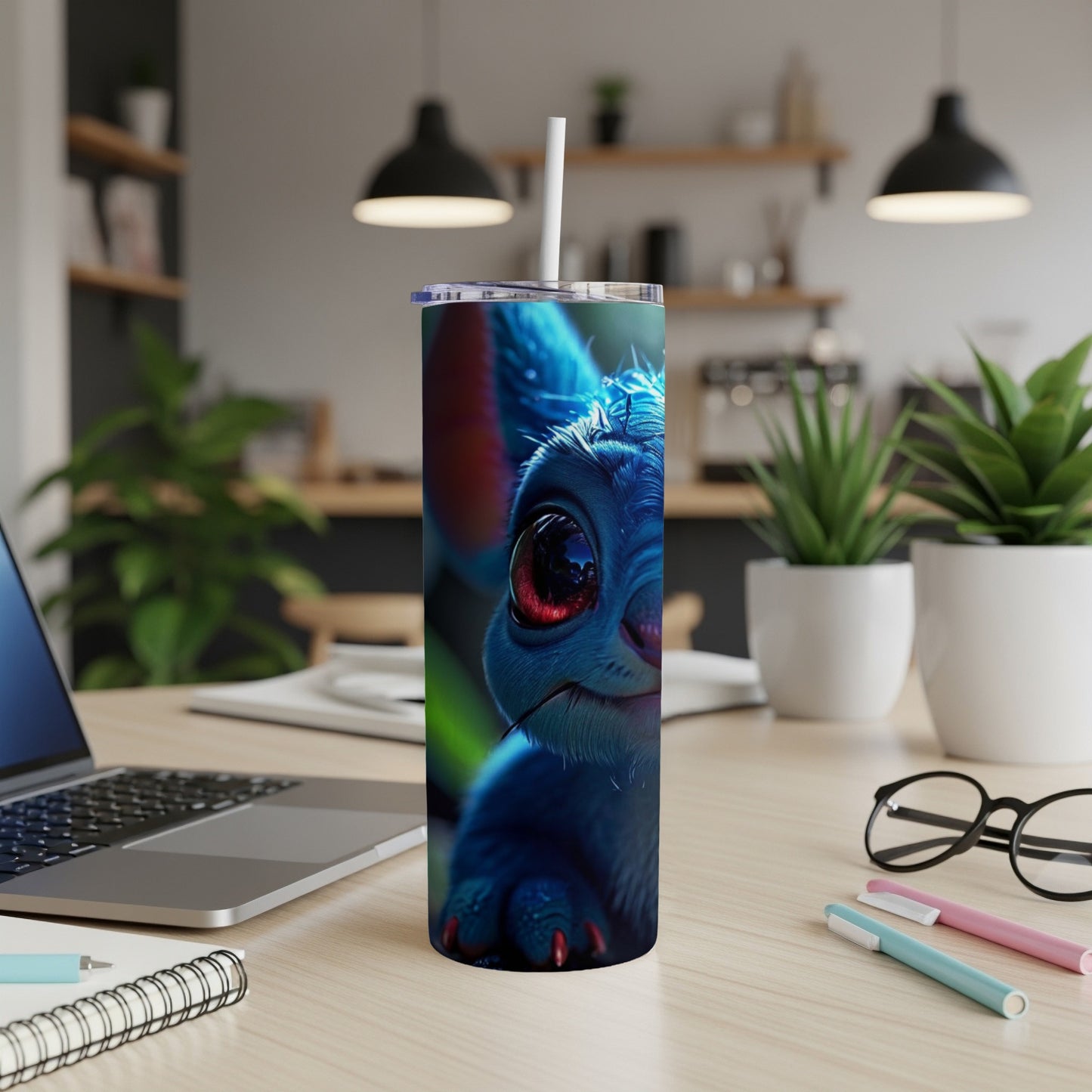 Blue creature with large eyes on a slim tumbler with straw.