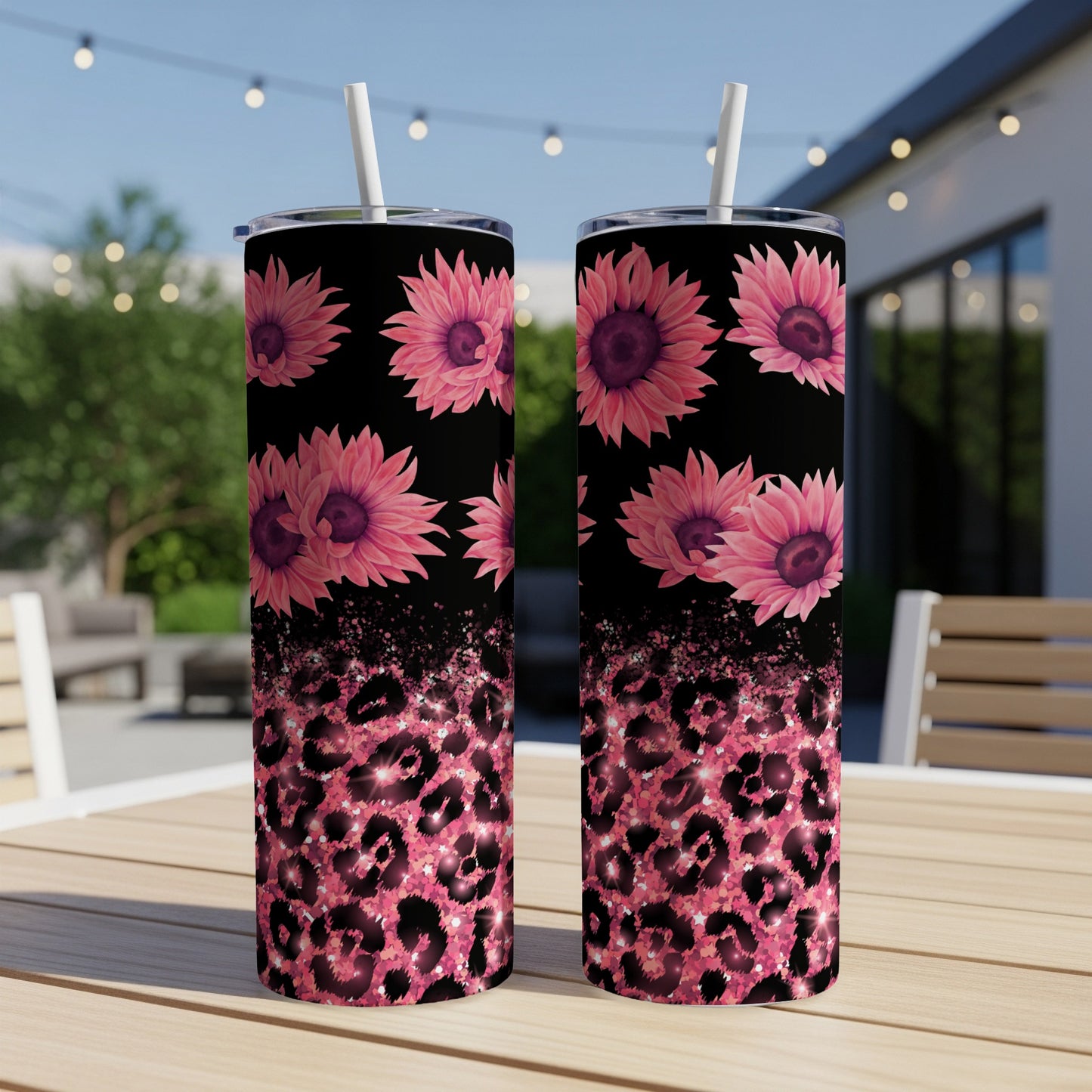 Two pink floral tumblers with leopard print and glitter on a table.