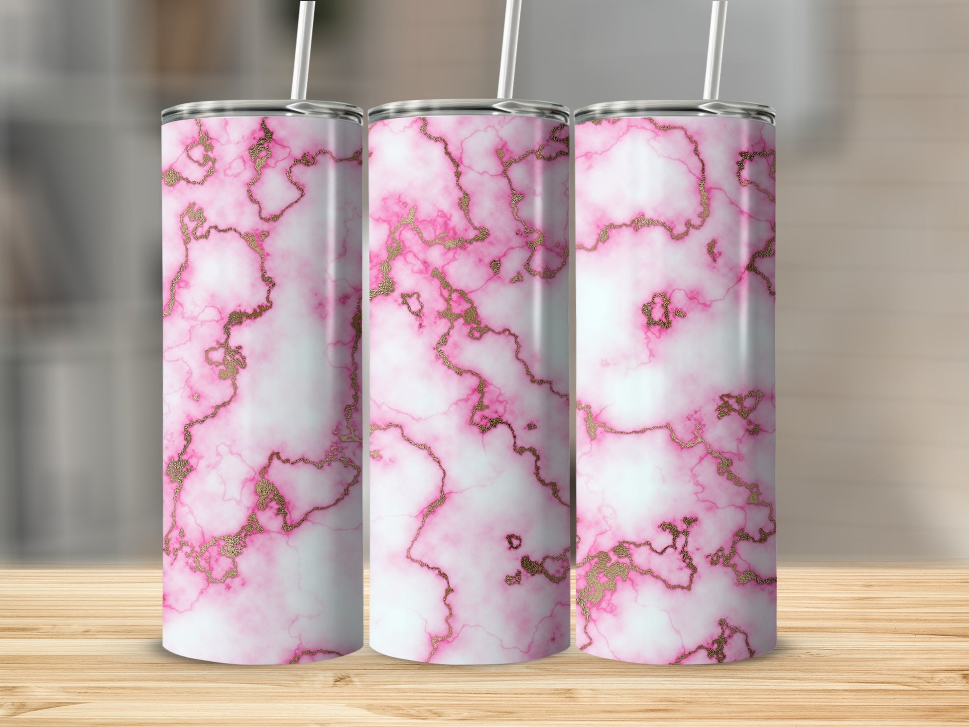 Three pink marble tumblers with gold accents and straws.