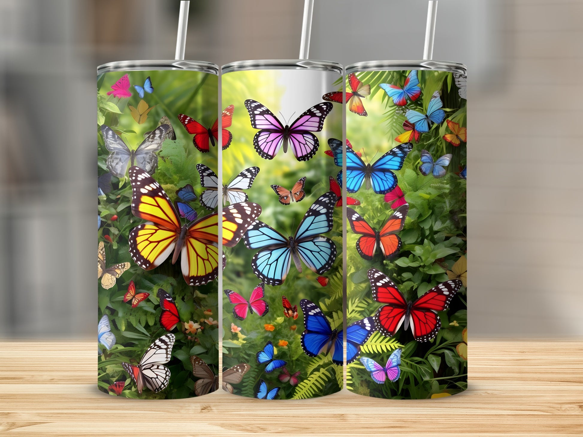Three tumblers with colorful butterflies and foliage designs.