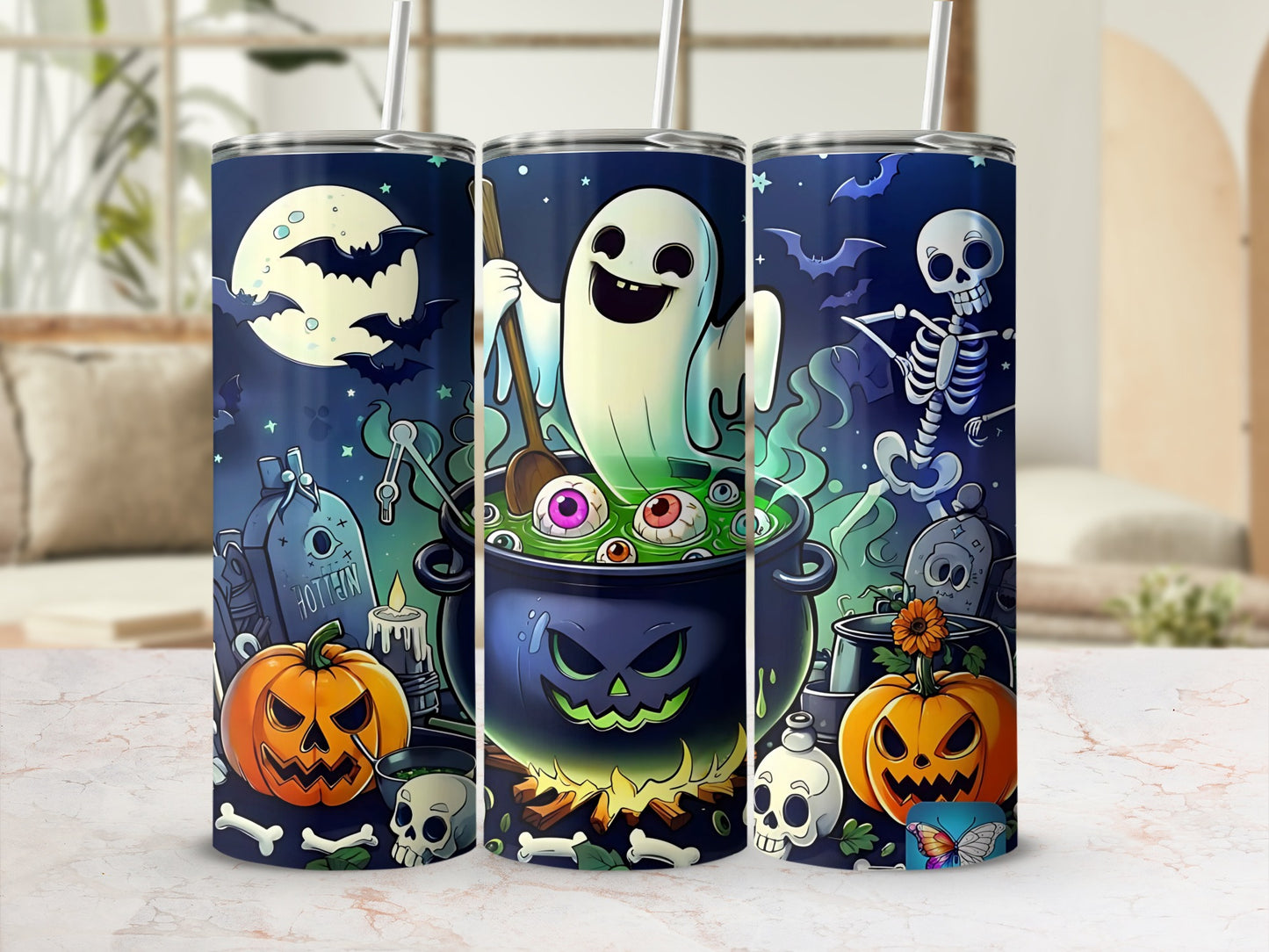 Three tumblers with Halloween art: ghost, skeleton, pumpkins, bats, and graveyard scene.