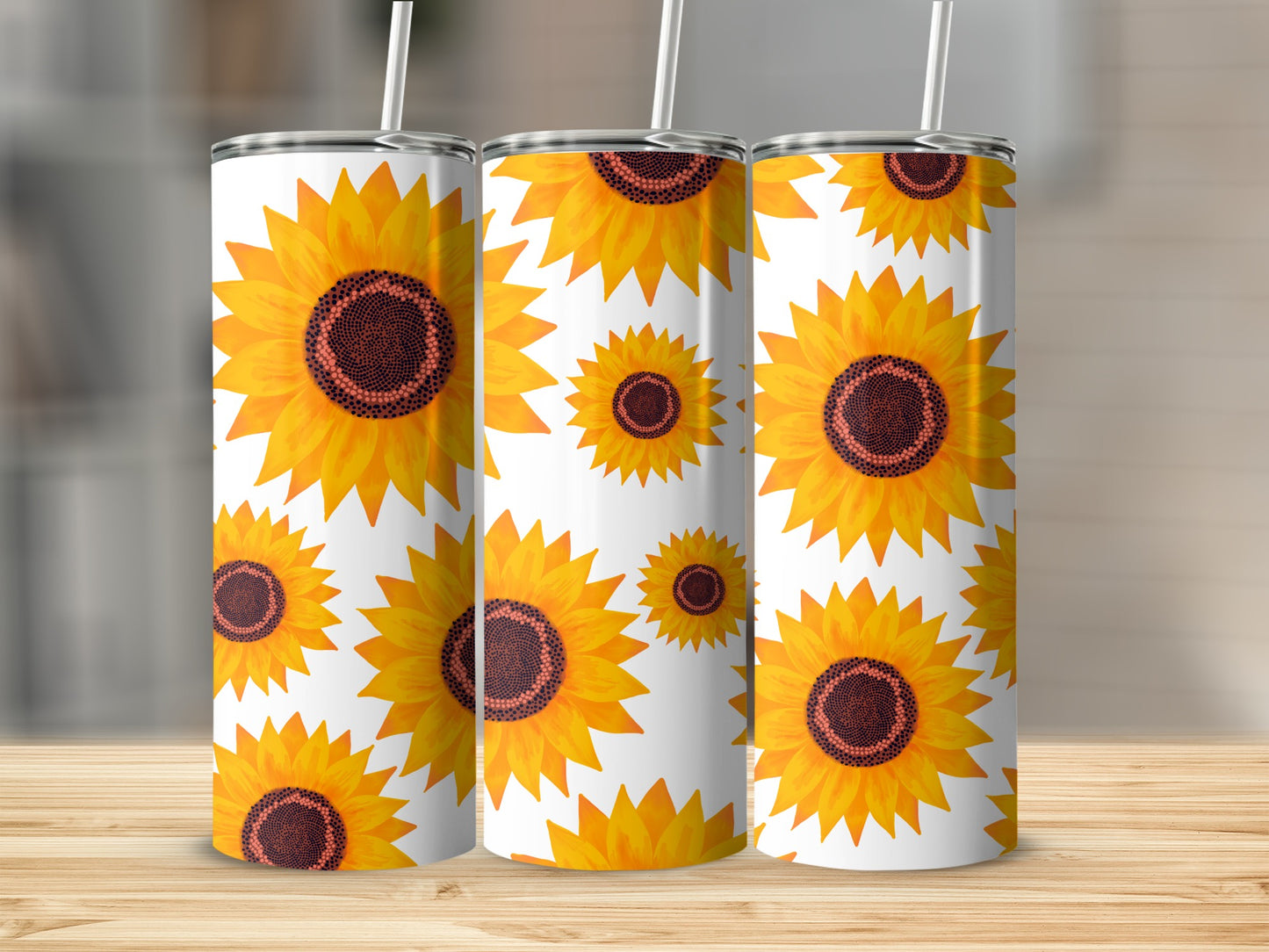 Three tumblers with a repeating sunflower pattern on a wooden surface.