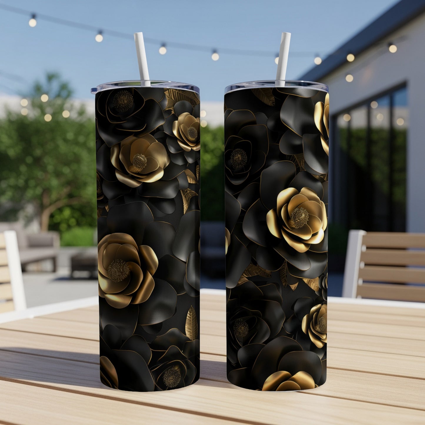Two black tumblers with gold floral designs sit on a table.