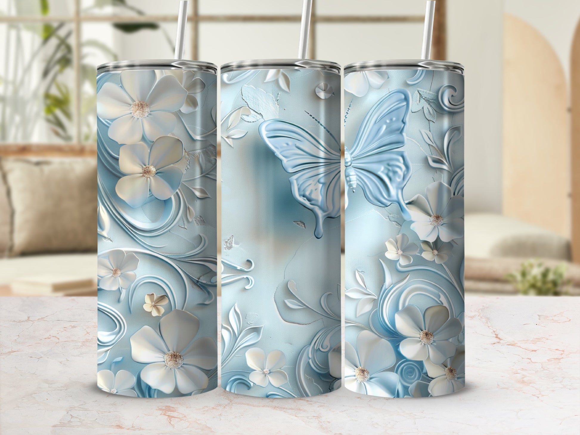 Three blue tumblers with raised white floral and butterfly designs.