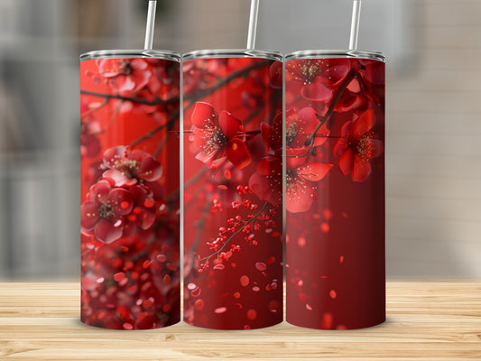 Three red floral tumblers with white straws, set against a blurred background.