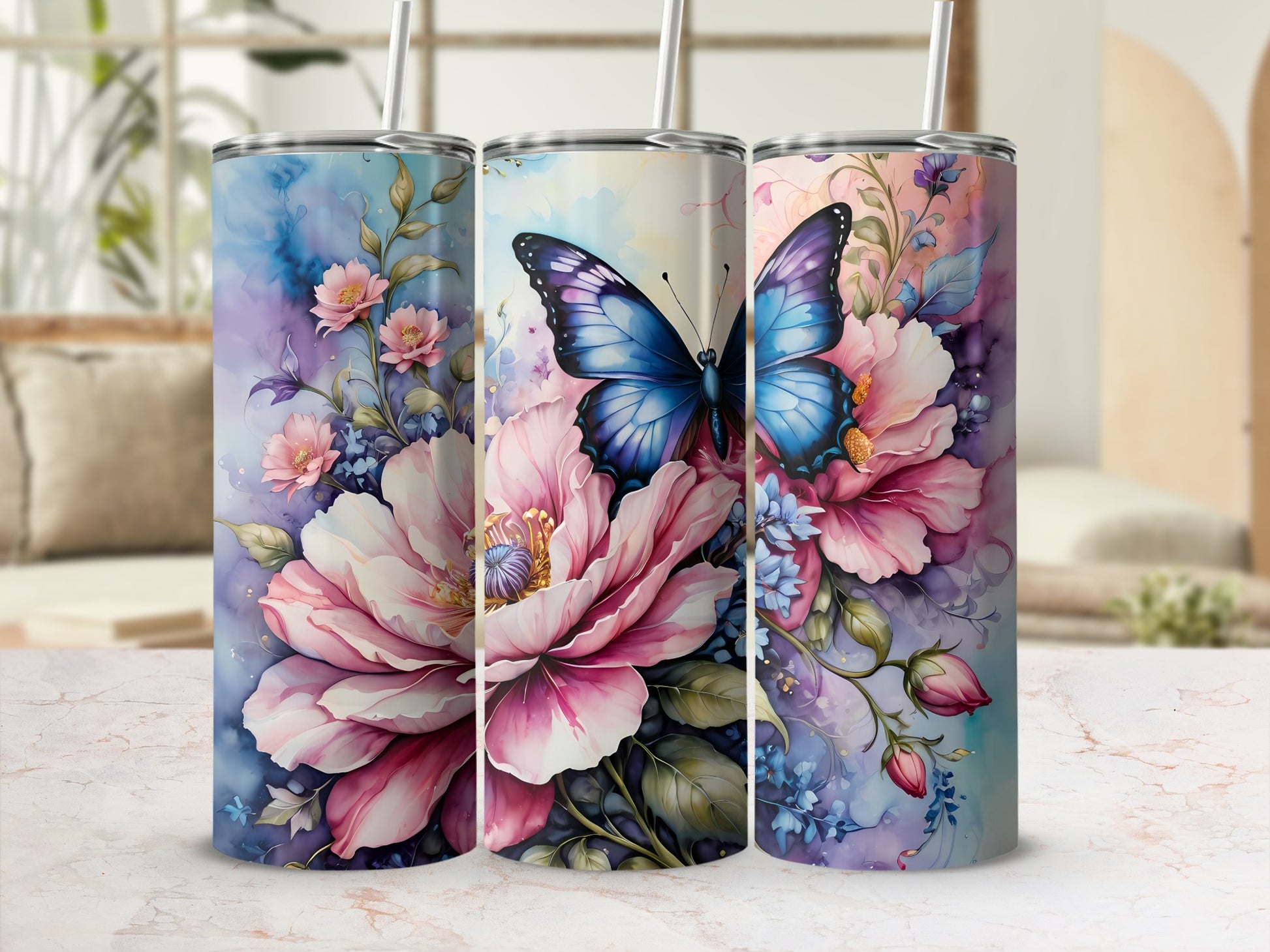 Three tumblers with floral and butterfly designs sit on a marble countertop.