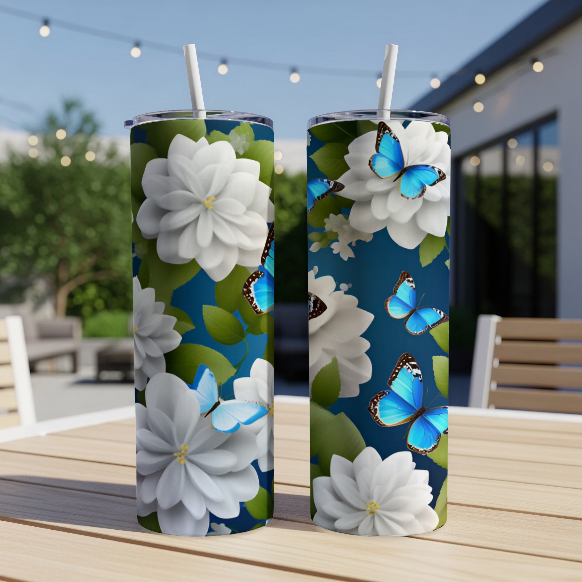 Two tumblers with white flowers and blue butterflies on dark blue background.