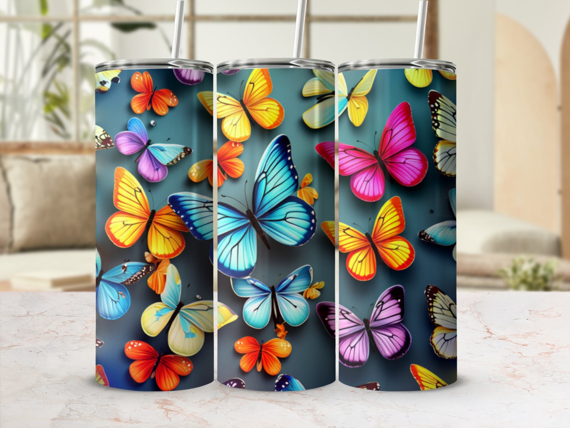 Three tumblers with colorful butterfly designs on a blurred background.