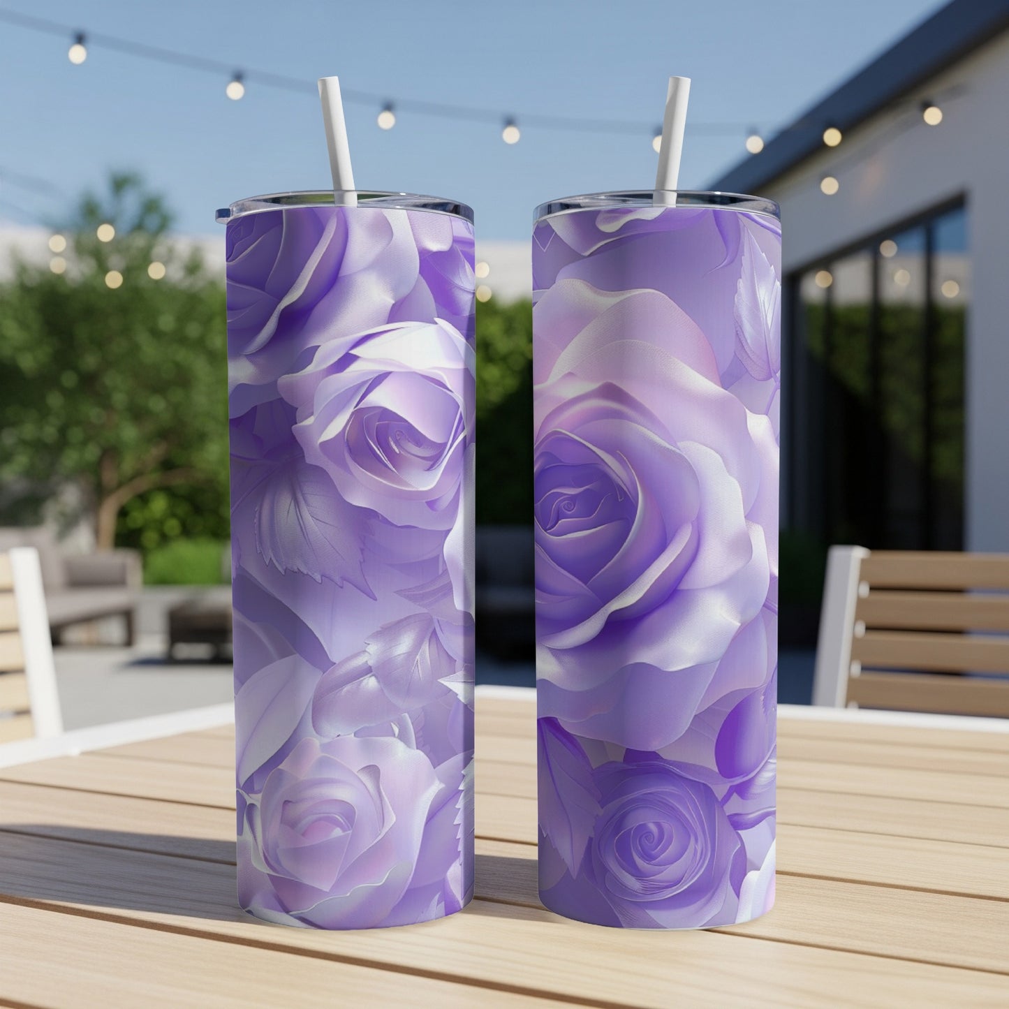 Two purple rose patterned tumblers with straws on a wooden table.