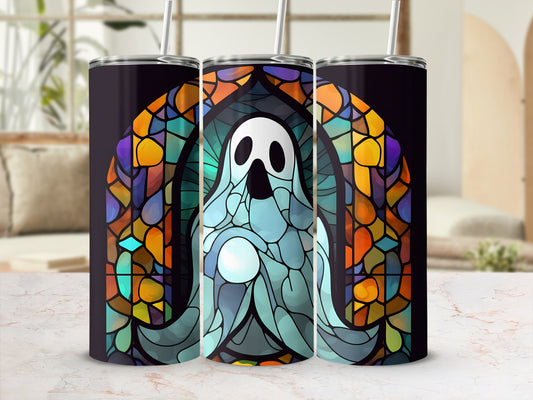 Stained glass ghost tumbler with straw against a blurred room background.