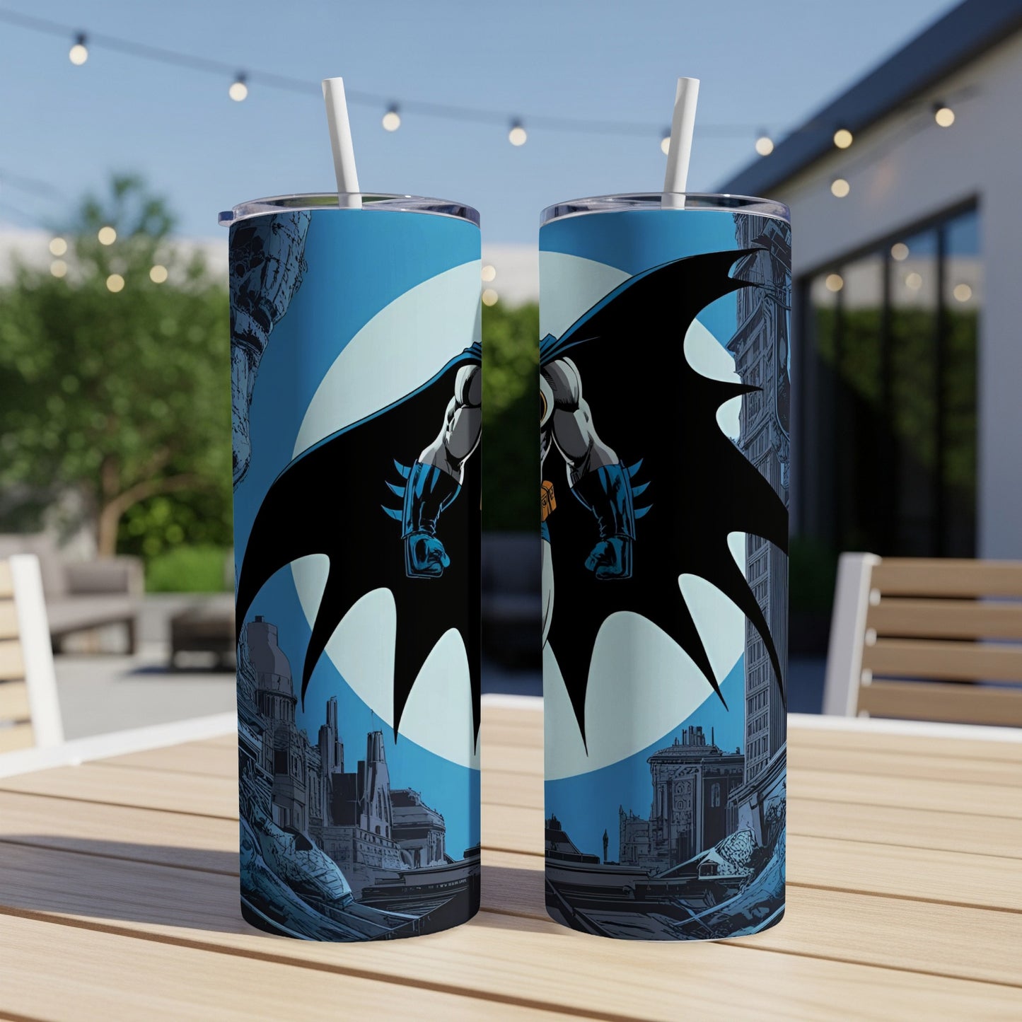 Batman artwork on two slim tumblers with straws, set outdoors.
