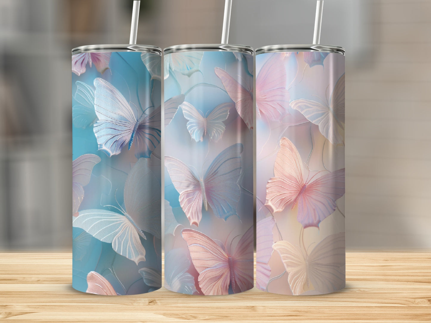 Three pastel butterfly tumblers on a wooden surface.