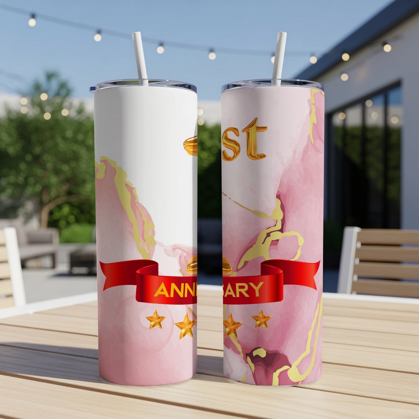 Two pink marble tumblers with "ANNIVERSARY" and gold accents on a table.