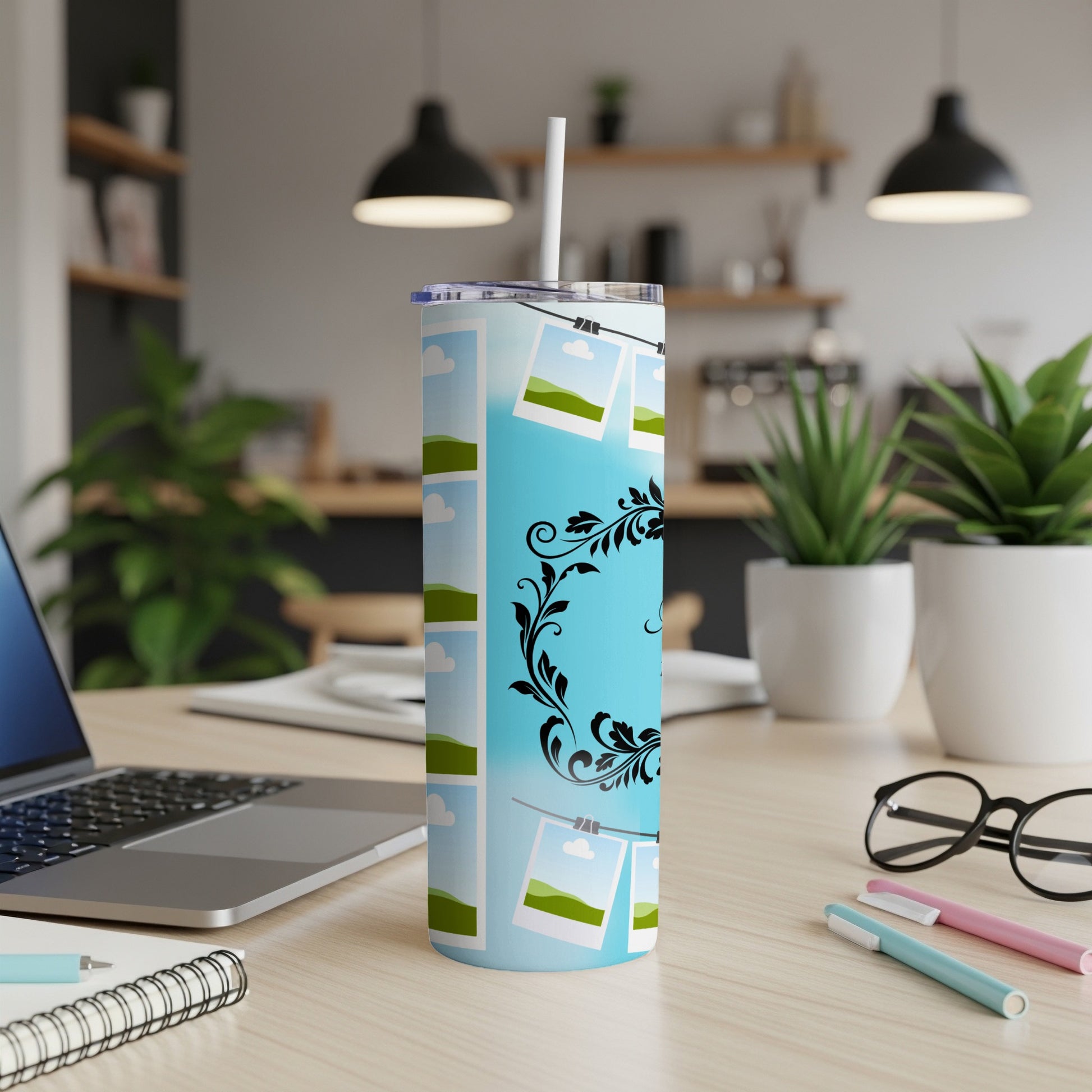 Blue tumbler with a sky and cloud pattern, featuring hanging photo frames and floral accents.