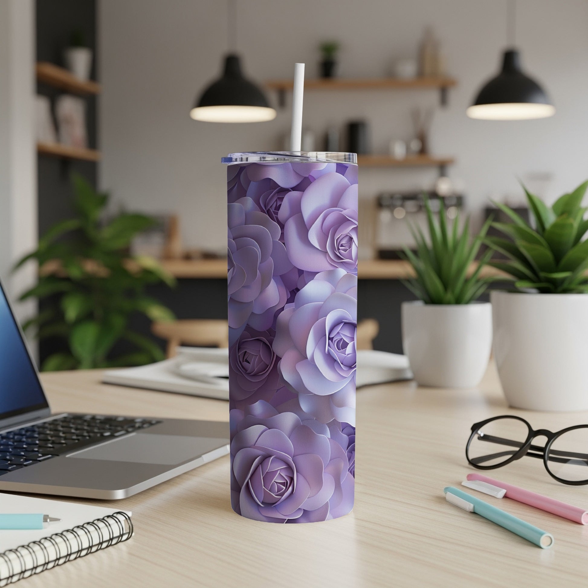 Purple floral pattern tumbler with straw on a desk.