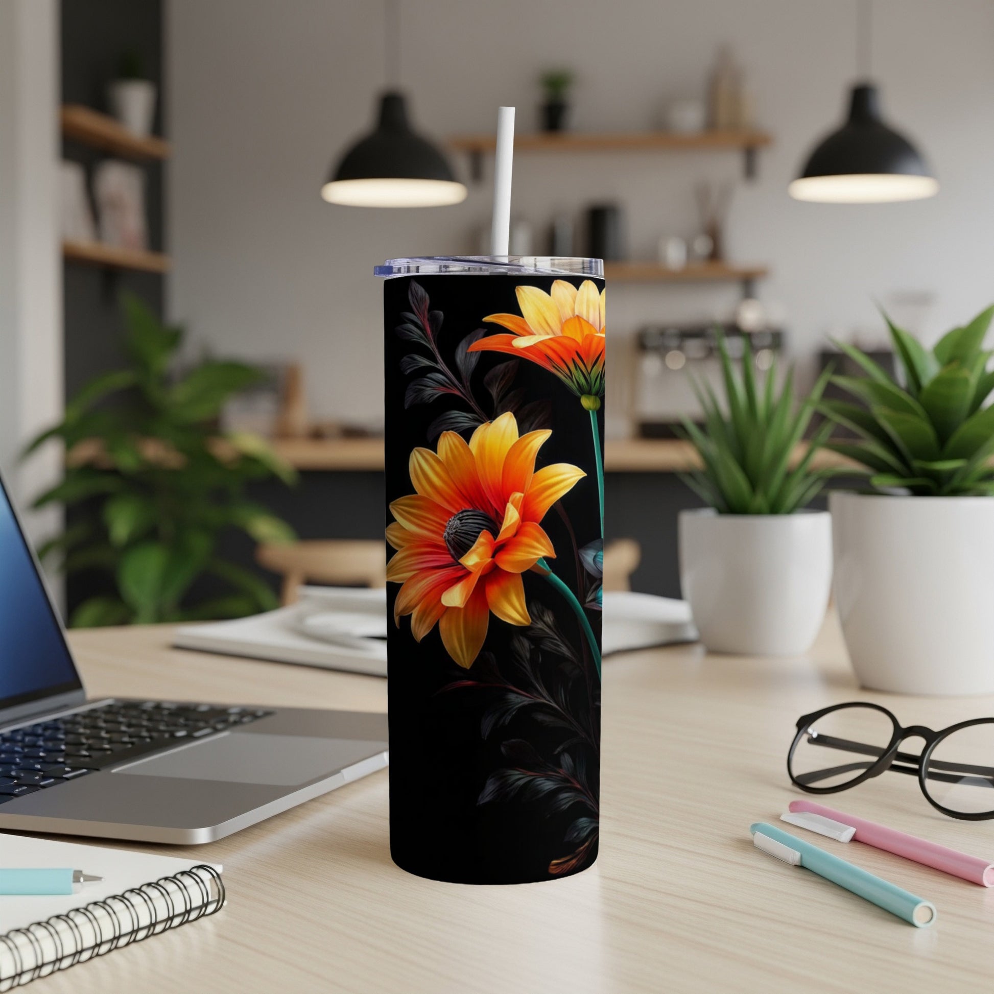 Black tumbler with vibrant orange and yellow flowers and dark leaves.