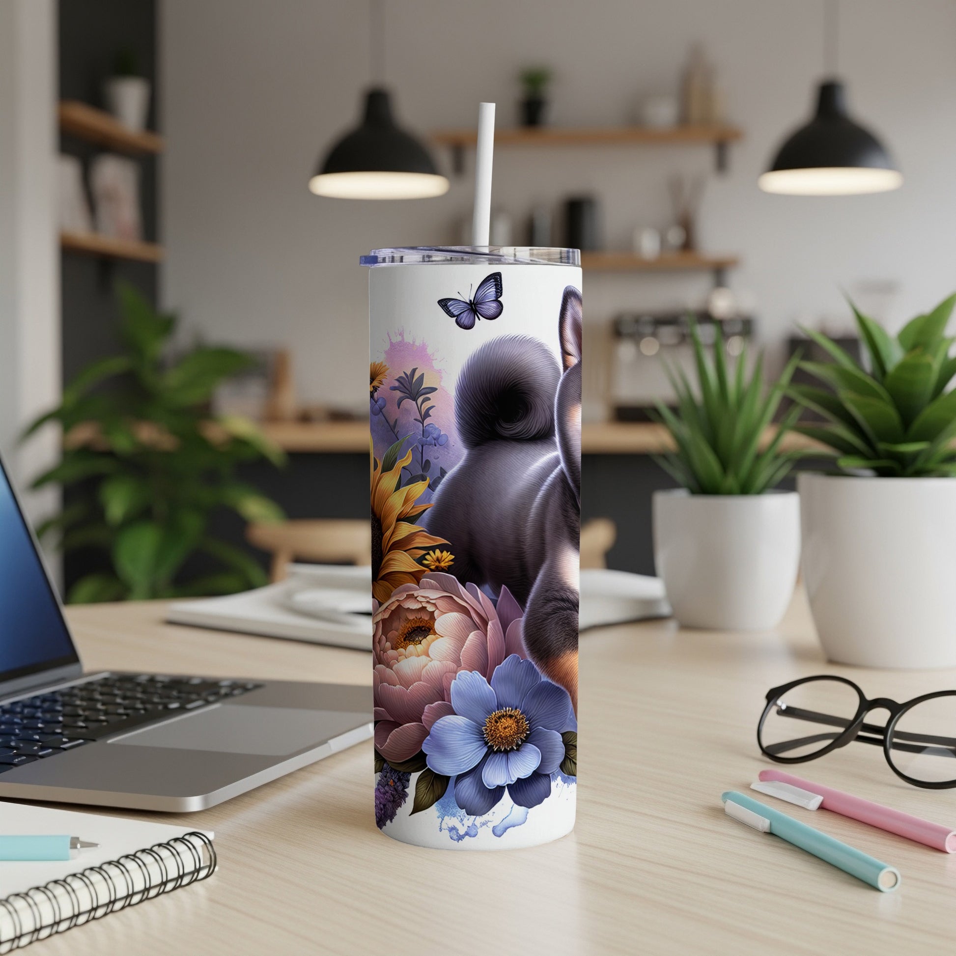 Black dog with colorful floral accents on a white tumbler.