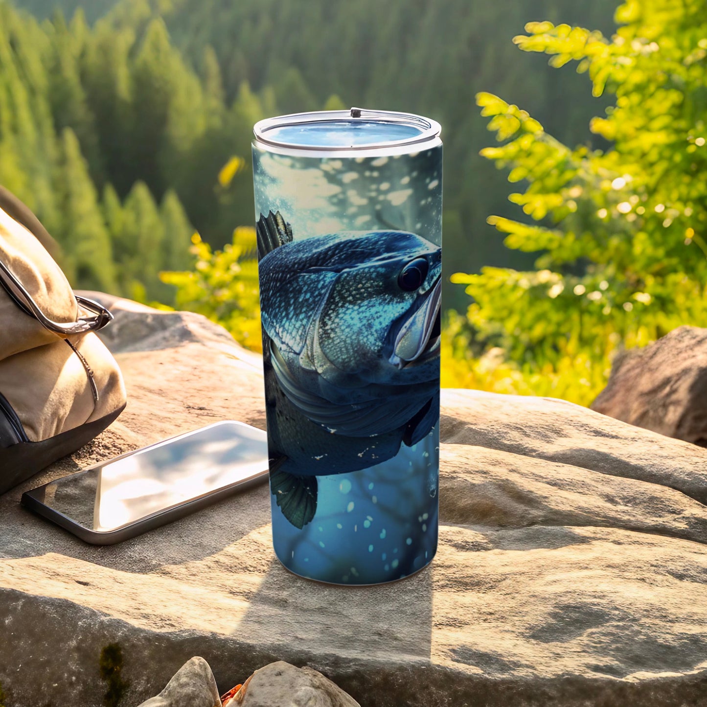 Bass fish illustration on a blue speckled tumbler with a smartphone and backpack.