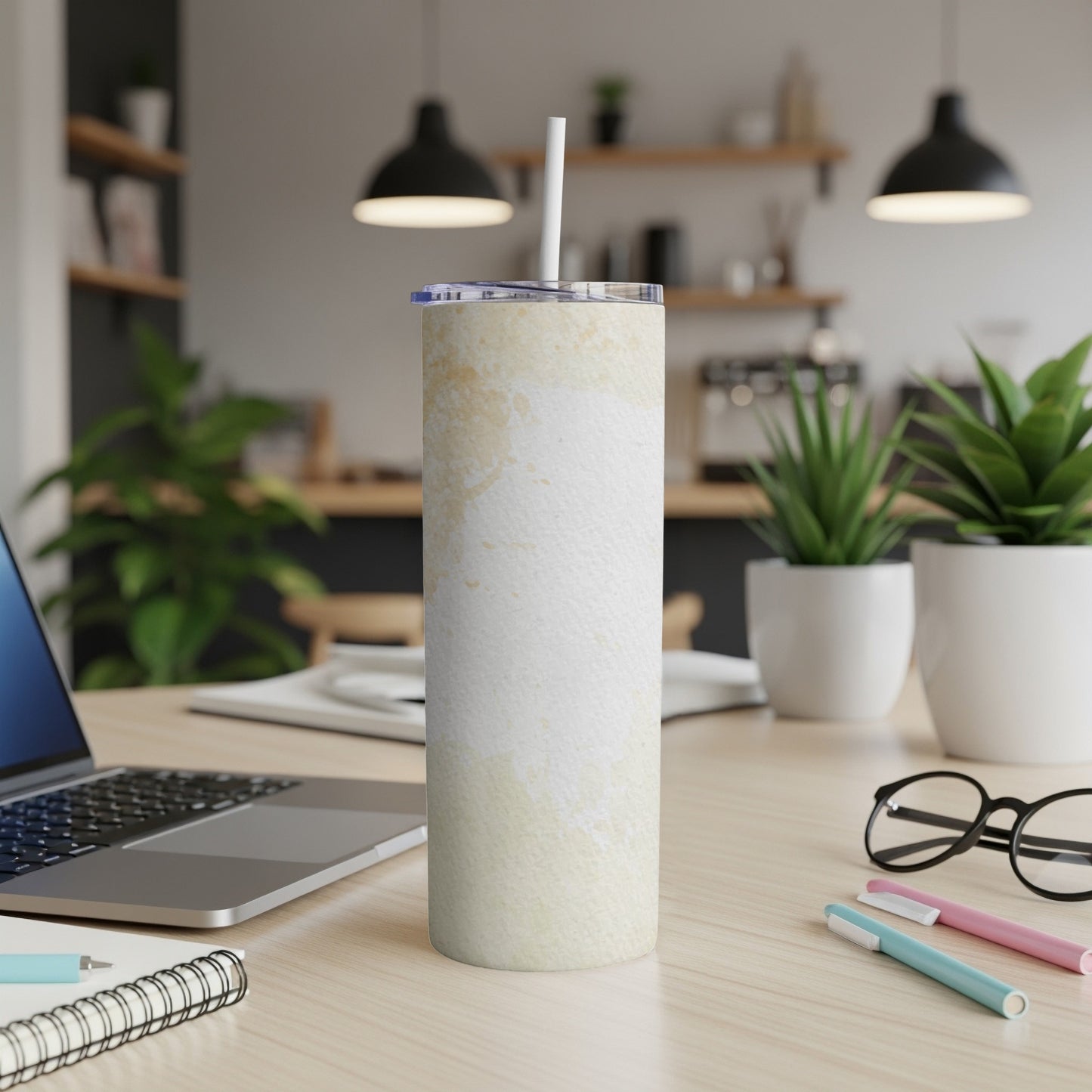 White tumbler with cream-colored abstract watercolor design and straw.