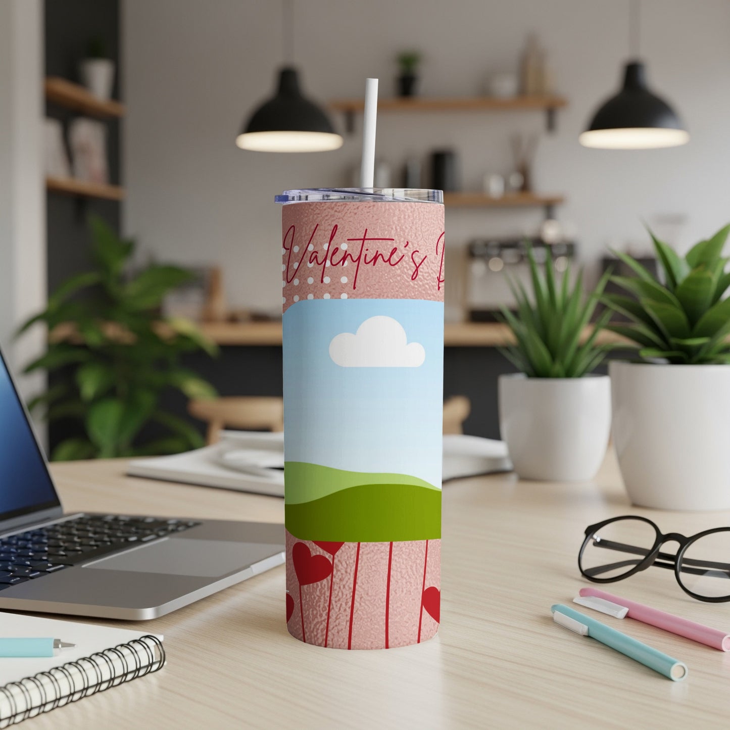 Pink tumbler with "Valentine's Day" text and heart design on a desk.