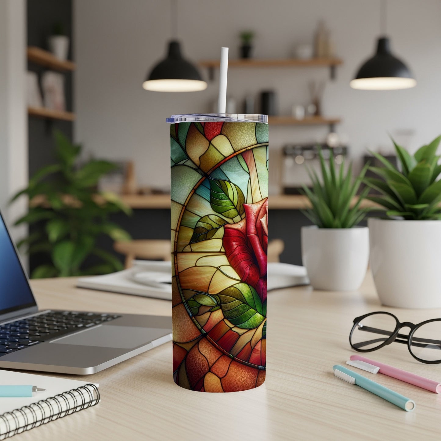 Stained glass rose tumbler with straw on desk.