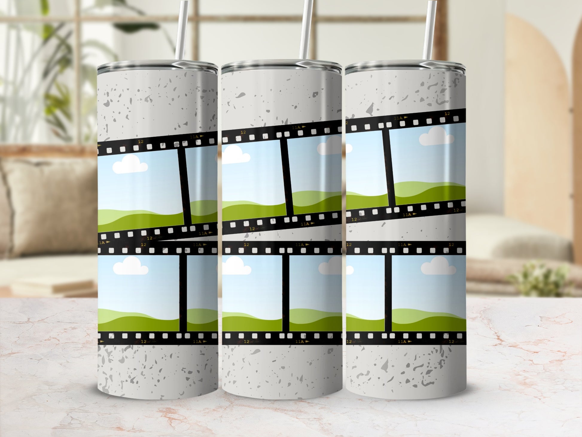 Three tumblers with film strip design and sky and rolling hills scenes.