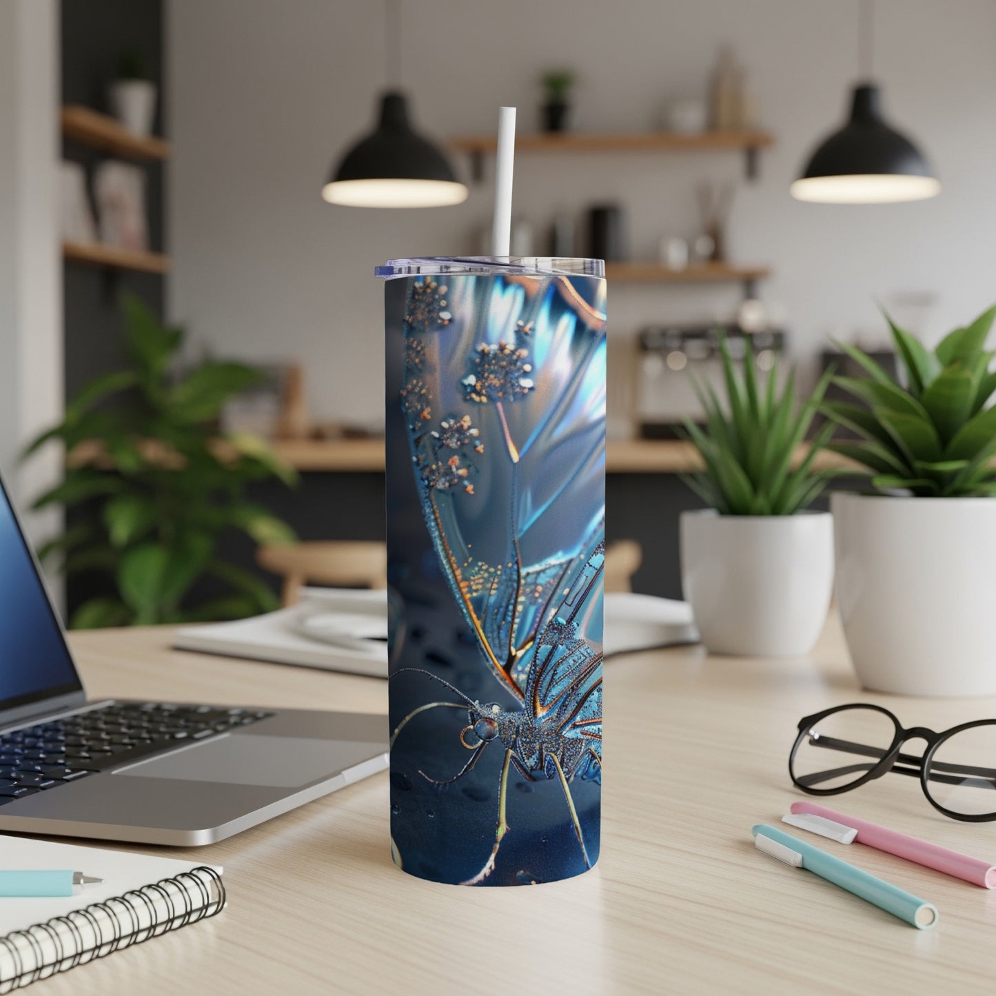 Blue iridescent butterfly tumbler with straw on a desk.