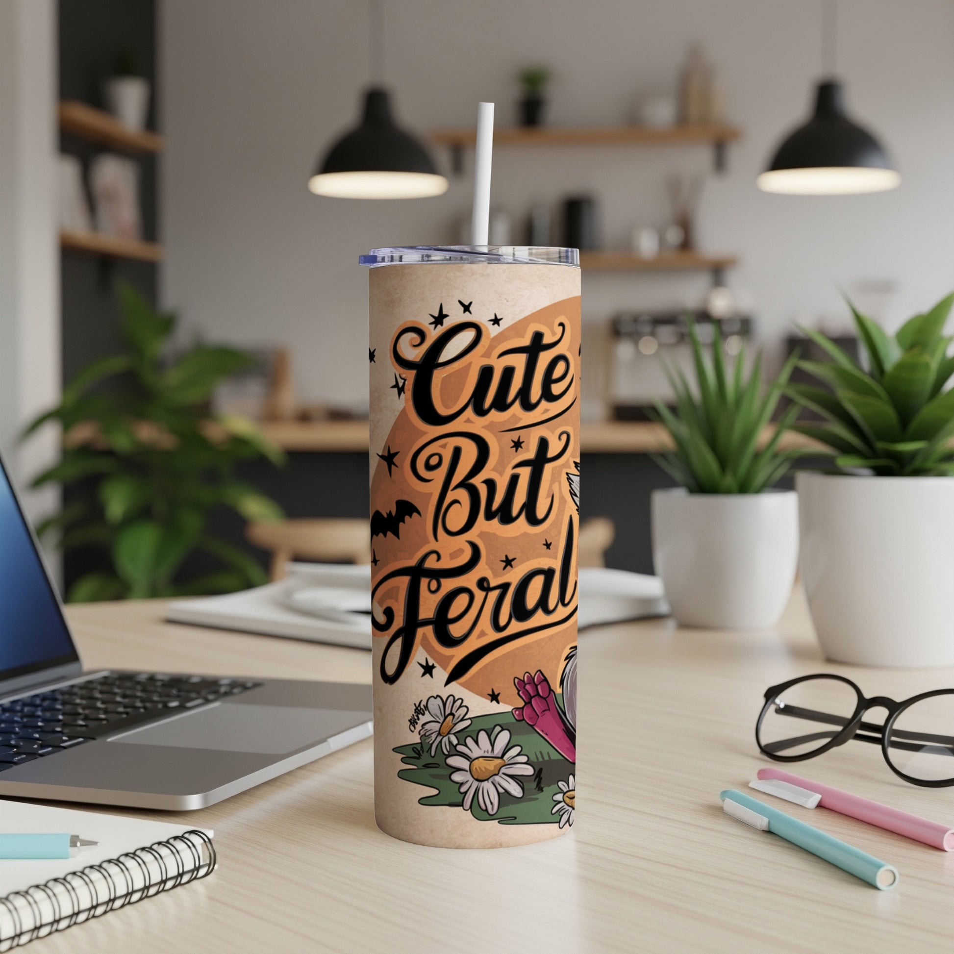 Tumbler with "Cute But Feral" text, bats, and daisies design.