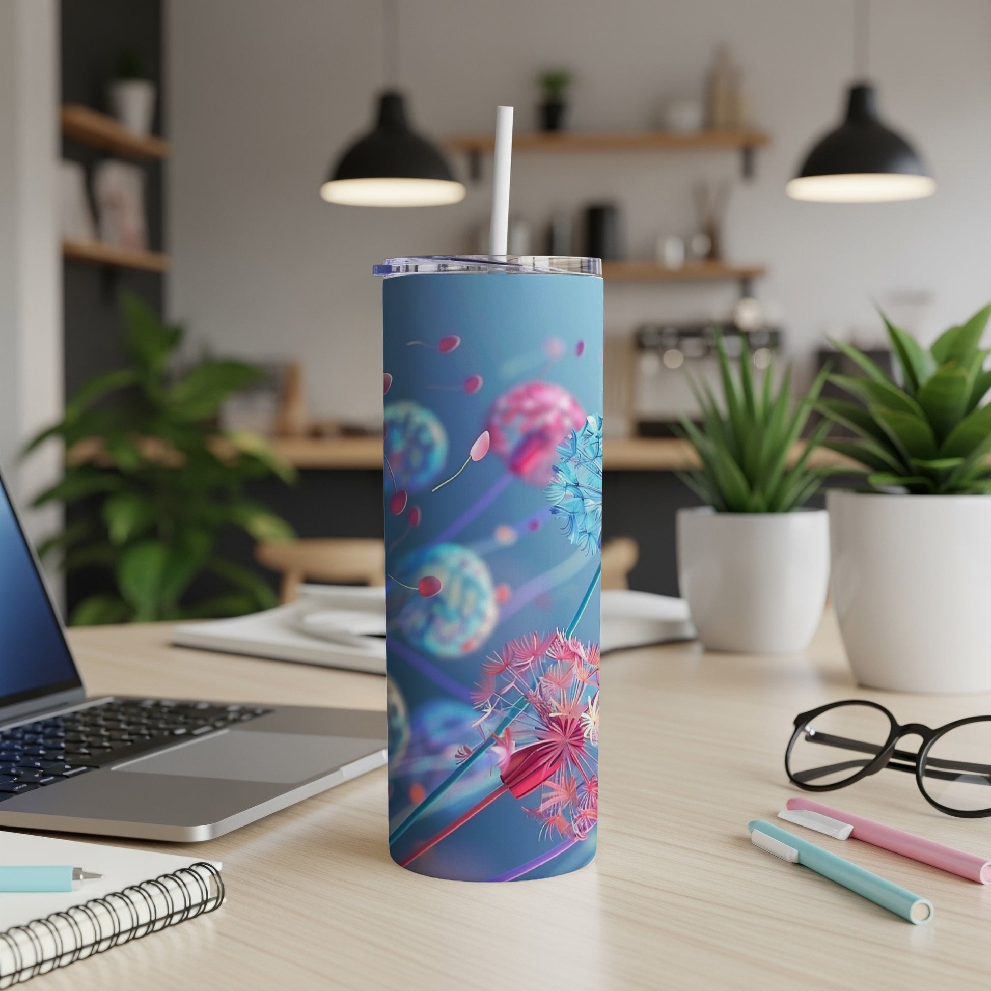 Blue tumbler with dandelion and seed graphics, straw in top.