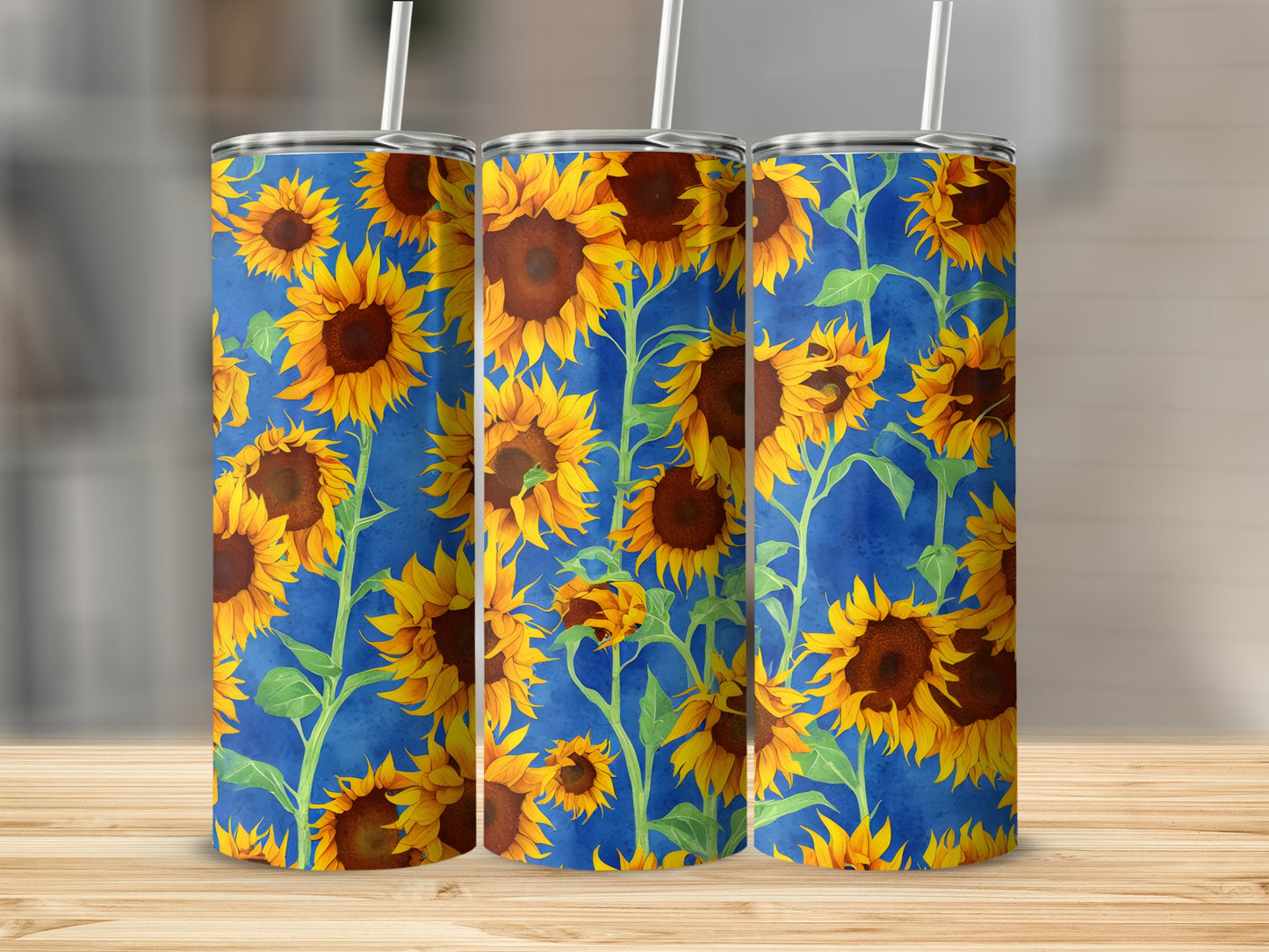 Three tumblers with a repeating sunflower pattern on a blue background.