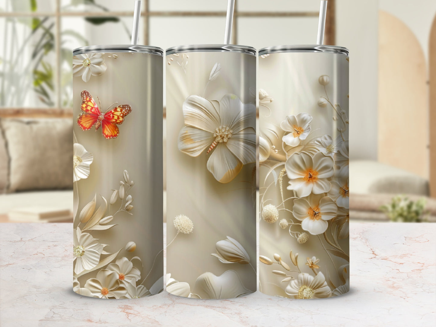 Three tumblers with floral and butterfly designs on a light-colored background.