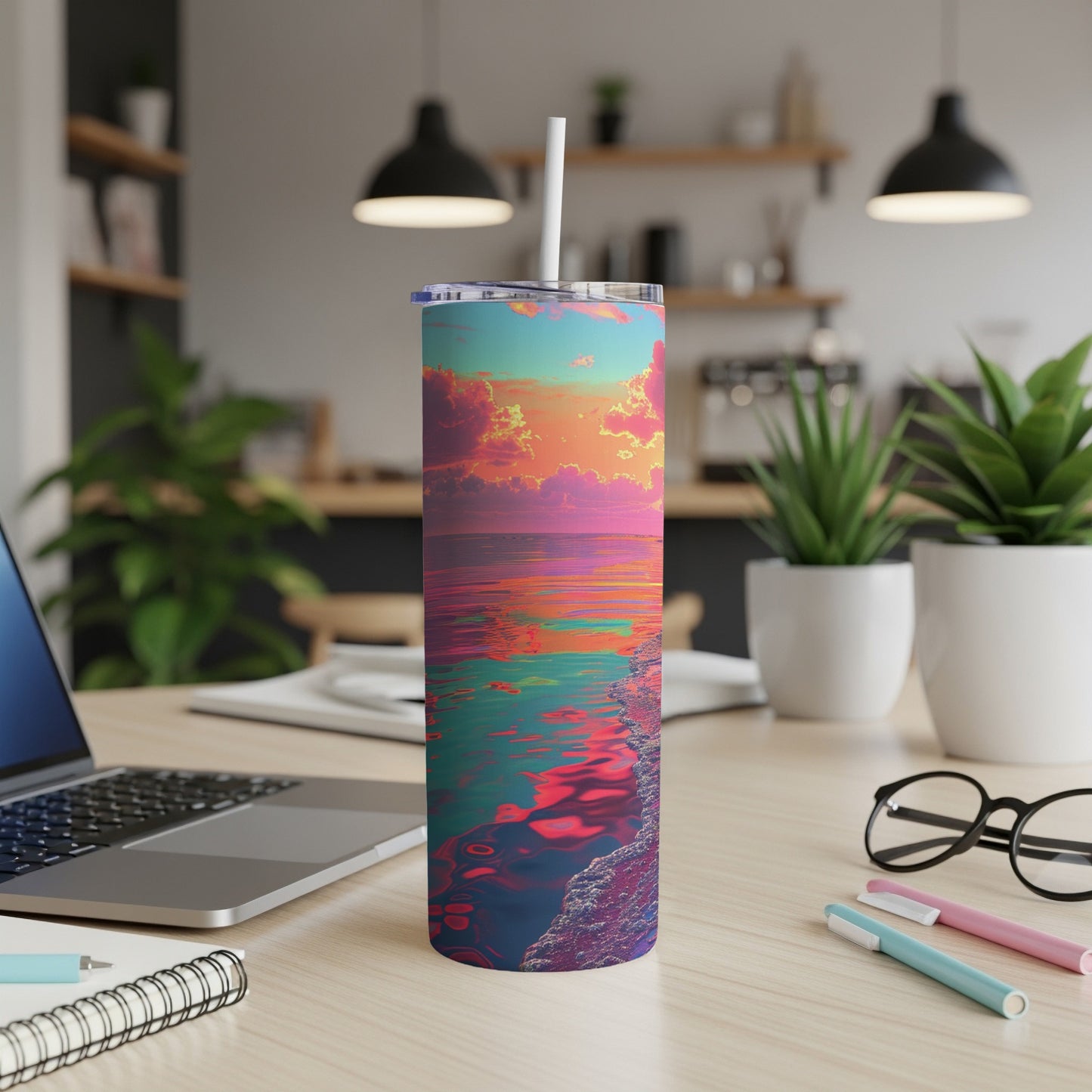 Colorful sunset over ocean on a skinny tumbler with white lid and straw.