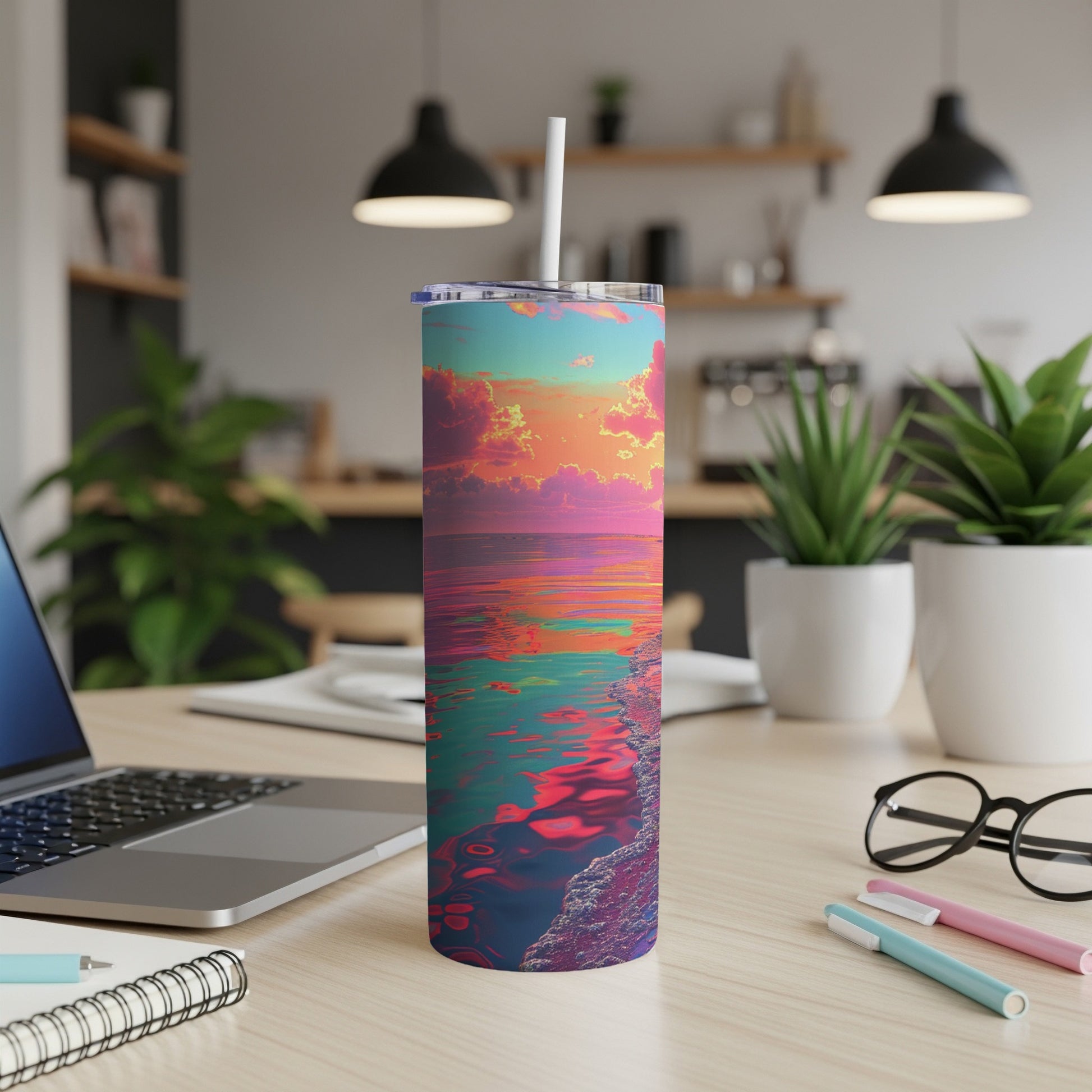 Colorful sunset over ocean on a skinny tumbler with white lid and straw.